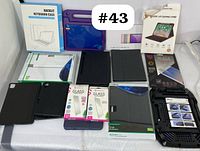 Full spread of accessories including keyboard cases, tablet covers, and screen protectors arranged on a table, with some original boxes visible.