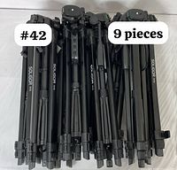 Photo of nine folded Soligor T175 camera tripods stacked together