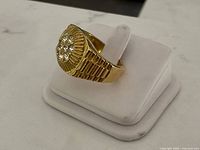 Front three-quarter view showing raised starburst top with seven glass stones and textured shoulders