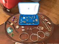 Overview of all items on table including Birks box, watches, bracelets, earrings, necklaces