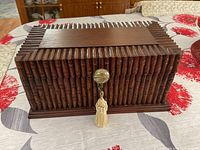 Front view of wooden box showing bamboo design and brass knob with tassel