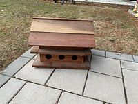 Full view of the assembled base birdhouse with pitched roof and three bird entrance holes visible on front.