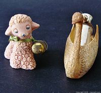 Two miniature animal holders seen side by side: a swan and a pink lamb, each with small vintage perfume bottles.