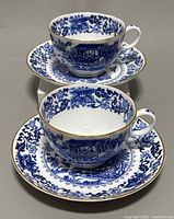 Two Royal Worcester vintage fine bone china teacups and saucers stacked, showing full pattern and gold trim.