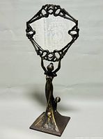 Front view showing entire figural base and framed round mirror