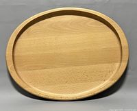 Top view of the oval wooden serving tray with raised edge, natural light wood finish, showing overall shape and condition.