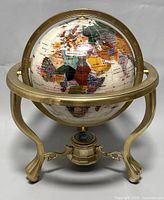Front view of mother-of-pearl globe on gold-tone metal stand