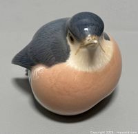 Front and right angle view showing the bird's head turned slightly upward, glossy finish, and detailed plumage.