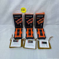Three Fuzion FU-200 digital pocket scales with black and orange rugged design, their retail boxes, warranty cards, AAA batteries, and yellow velvet protective pouches, displayed from front angle.