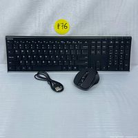 Image showing full wireless keyboard with keys visible, black ergonomic mouse, and USB charging cable laid out on a white surface.