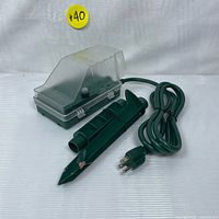 SURAIELEC outdoor power stake timer front with transparent cover and green stake, 6-foot extension cord and 3-prong plug.