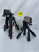 Two black portable mini tripods with ballhead mounts, standing upright showing legs and mounting plates, marked with lot number.