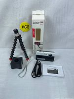Full bundle: digital camera, tripod, tripod box, USB cable, and manual.