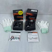 Two pairs of Sealight LED headlight bulbs in black foam inserts, with two pairs of white gloves and instruction manuals on a white cloth background.