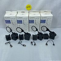 Four boxed W Mounts Wall Mount for Nest Cam packages with four unboxed mounts, four mounting bases, and four short USB cables laid out in a row.