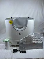 Main ramp base with detached grate, filter cartridge roll, liners and power adapter laid out