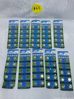 Ten cards of T&E alkaline button cell batteries arranged in two rows, each card containing 10 batteries, blue and white packaging with product details and branding.
