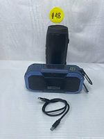 Both speakers shown together with one charging cable visible