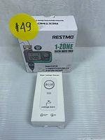 Box for Restmo 1-Zone Digital Water Timer and white Leakage Detector device with alarm light shown front-facing