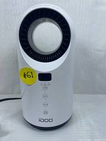 Front view of the white Idoo ceramic heater showing fan opening, LED display, and control buttons.