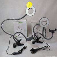 Two LEDGie 2-in-1 ring lights displayed with flexible arms, clips for mounting, phone holders, and attached USB cords.