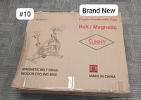 Sealed cardboard box showing printed bike illustration, branding, model number, and handling labels