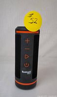 Front view of black and orange Bushnell Wingman GPS speaker showing control buttons and Bushnell Golf logo.