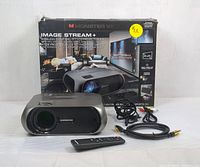 Packaged Monster Vision Image Stream+ wireless projector kit with projector, remote, and cables in front of the box.