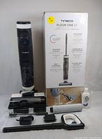Photo of Tineco FLOOR ONE S3 vacuum with box and accessories: main unit, roller brush, cleaning solution, filter, brush tool, dust container, and wand attachment