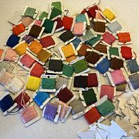 Scattered assortment of coloured DMC floss wound on bobbins