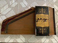 Full view of autoharp showing strings, chord bar, wood body