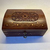 Top view showing carved floral lid and brass inlay