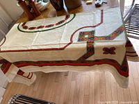 Full view of tablecloth draped over table showing size and border pattern