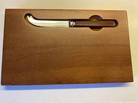 Top view of maple cheese board with knife in recessed slot