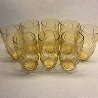 Front view of eight amber tumblers showing diamond texture