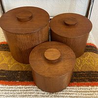 front view of all three teak canisters with lids