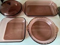 Four amethyst Pyrex pieces: casserole with lid, rectangular baker, square baker, pie plate