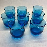 Front view of eight turquoise glass tumblers