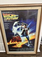 Framed Back to the Future movie poster showing Marty McFly and DeLorean with title and credits visible.