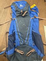 Front view of Gregory backpack showing blue and gray nylon fabric, front buckles, and mesh side pockets.