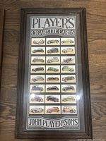 Framed John Player & Sons cigarette card collection depicting classic cars in 24 cards arranged 6x4 with branded header and footer.