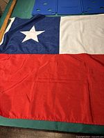 Close-up image showing the Texas flag made of polyester, featuring a single white star on blue, and horizontal white and red stripes.