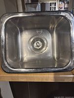 Top view showing the rectangular stainless steel sink basin with central drain and strainer.