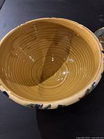 Top view of handmade ceramic bowl showing glossy brown interior with circular ridges.