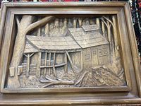 Front view of hand carved wooden wall hanging showing a detailed sugar shack with trees and rustic features.