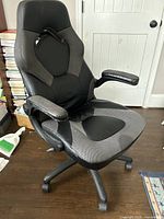 Front angled view of complete black office chair showing seat, armrests, and five caster base.