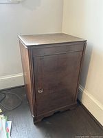 Closed brown wooden cabinet with traditional design and visible surface wear.