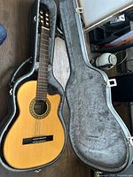 Guitar and hard case opened, top-down view showing full lot contents