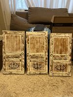 Three rustic framed mixed media art panels placed side by side on carpeted floor