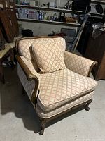 Front and side view of the wooden frame traditional armchair with beige fabric and pink plaid pattern. Chair includes one matching cushion.